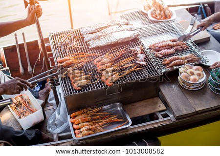 BBQ grill seafood on boat at Amphawa river market in Thailand Royalty-Free Stock Photo #1013008582