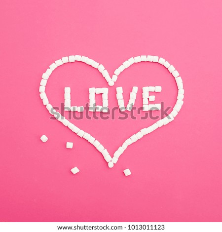 Valentines day concept made of marshmallows on pink background. Heart of candy. Flat lay. Top view