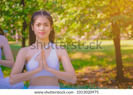 Group people have meditation for yoga.In the morning they are sitting on mat and play yoga in park.good air,hobby,Zen,Photo concept freedom and good health.