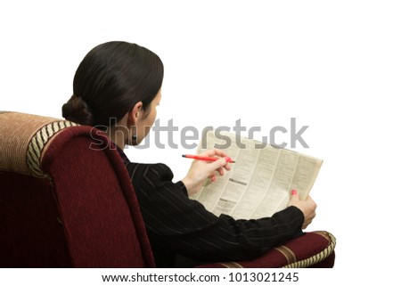 Young woman in a chair reading a newspaper with an advertisement - in search of work
