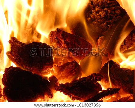 Fireplace - Hot Flames of Burning Coal Lumps and Heat. Radiant heating is warming interior of a house. Royalty-Free Stock Photo #1013027356