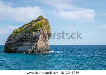 Big peace of rock in the sea near Budva in Montenegro. Small island in the sunny day.  Royalty-Free Stock Photo #1013041939