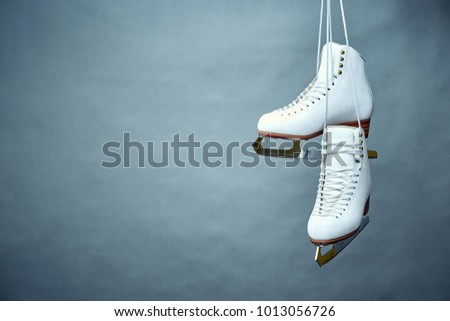 A pair of female white skates on a gray background. Royalty-Free Stock Photo #1013056726