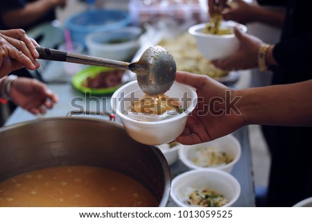 Feeding the poor to hands of a beggar. Poverty concept Royalty-Free Stock Photo #1013059525