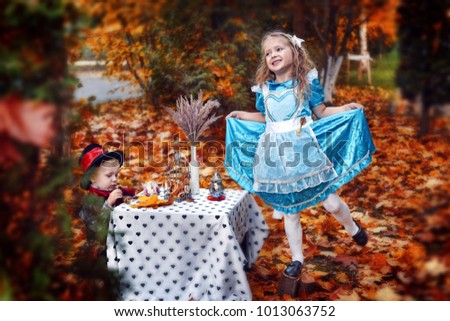 Little fairy-tail blond girl in blue dress in the golden forest
