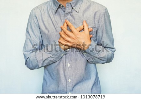 grown men with symptoms of acute recurrent heart attack. guy clinging heart on a blue background. chest pain. preinfarction angina, Heart failure, Angina, Tachycardia, Pericarditis, Royalty-Free Stock Photo #1013078719