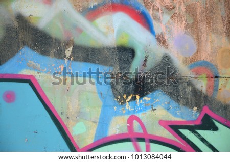 Close-up fragment of a graffiti drawing applied to the wall by aerosol paint. Background image of a modern composition of lines and colored areas. Street art concept