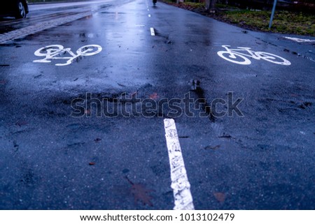 Wet bicycle path ways in a city during twilight with nice reflections