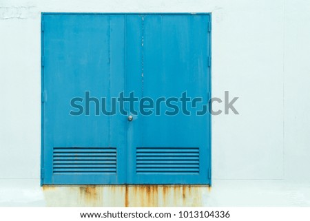 Old blue door with white concrete background.