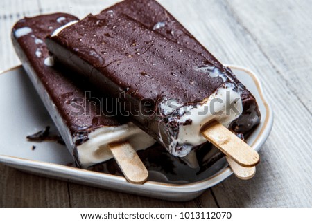 Chocolate ice-cream-dessert. Chocolate ice lolly on a light wooden countertop in vintage style