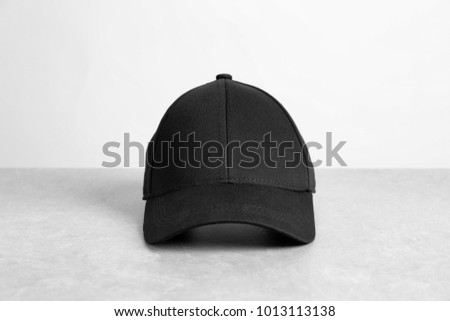 Black cap on table against white background. Mockup for design