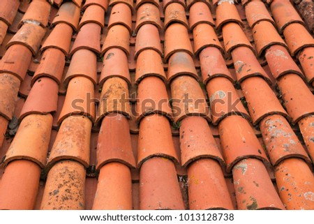 Close-up of red shingles shabby from the weather on the roof of house. Background image. Conceptual wallpaper