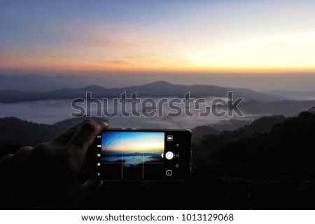 view of sea of mist through mobile phone screen