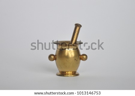 Vintage brass mortar with pestle isolated on white background. Miniature