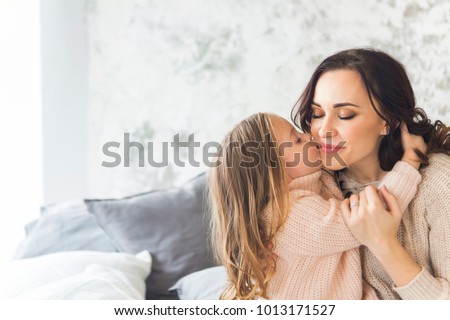 Young woman in the morning embrace with small girl. Love and family concept