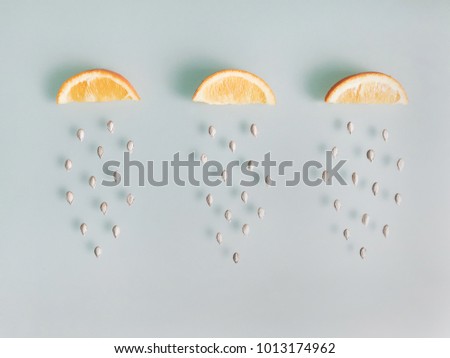 Creative fruit background made of sliced orange with falling seeds. Food flat lay. top view.