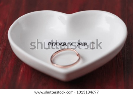 Small ceramic saucer in the shape of a heart with a ring and a n