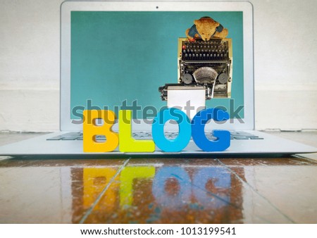 concept blogging with wooden letters on a laptop on a wooden floor  with reflection 