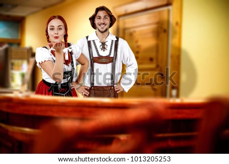 Two young bavarian people and their own small business. Hotel interior with reception. 