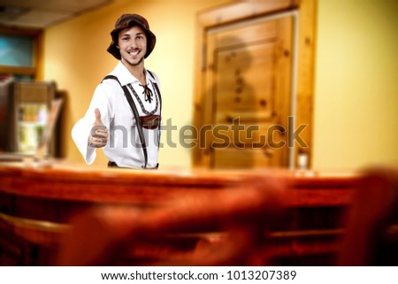 Young bavarian man and his own small business. Hotel interior background. 