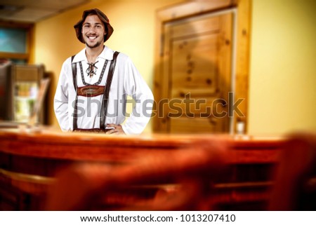 Young bavarian man and his own small business. Hotel interior background. 