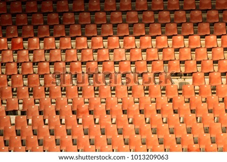 Orange empty chairs at the football stadium