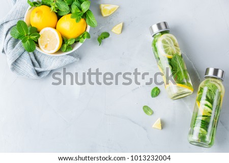 Health care, fitness, healthy nutrition diet concept. Fresh cool lemon cucumber mint infused water, cocktail, detox drink, lemonade in a glass jar. Light copy space top view flat lay background