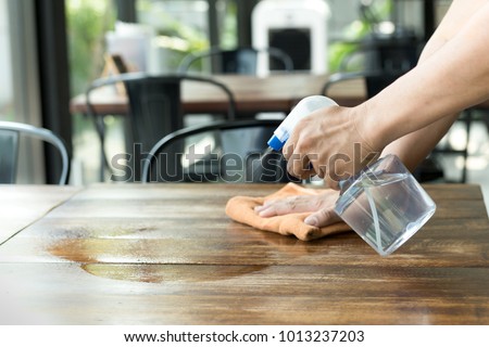 Waiter cleaning the table with Disinfectant Spray in a restaurant Royalty-Free Stock Photo #1013237203