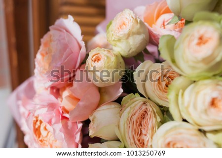 An amazing bouquet of diferent colourful flowers standing near the window. Romantic.