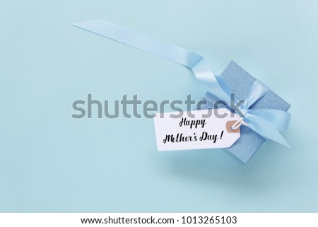 Top view aerial image of decoration Happy mother's day holiday background concept.Flat lay mom white card with blue gift box on beautiful modern grunge paper at home office desk.Free space for design.