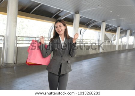 Attractive beautiful yong women holding shopping bag and credit card in modern city.Lifestyle shopping concept.