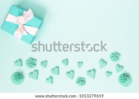Blue gift box with jewelery and many small heart and flowers are all around. The background is blue. The best gift for any holiday. Mock up. Free space for text.