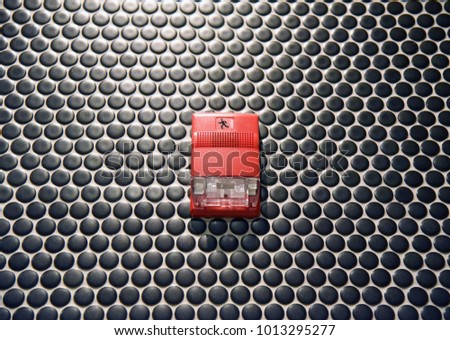 Fire alarm isolated on black dotted pattern wall