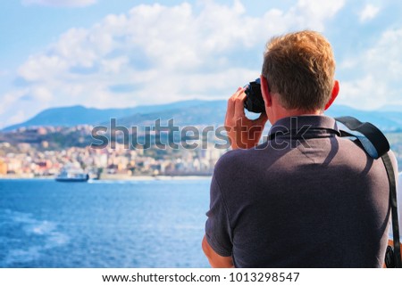 Man taking photos of the Mediterranean Sea and landscape in Reggio Calabria, Italy