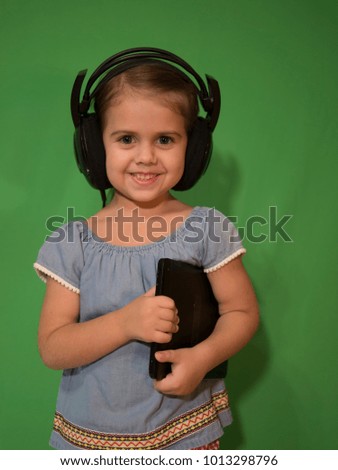 happy baby with headphones with the tablet in hand