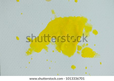 Yellow watercolor stains on white paper background.