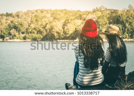 Woman tourist sitting on the river surrounded by rivers and mountains.