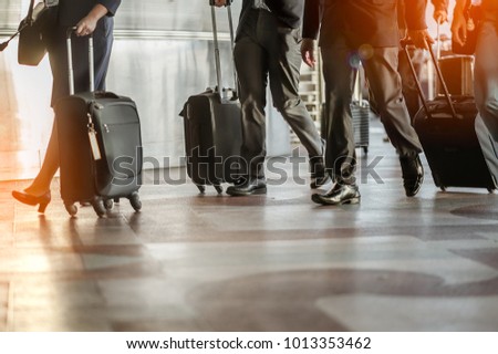 Close up of businessman team carrying suitcase while walking through a passenger boarding bridge.people and traveling luggage walking in airport terminal building Royalty-Free Stock Photo #1013353462