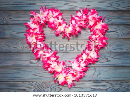 Hawaiian garland of flowers on a blue wooden background. love. romance. tourism. romantic trip