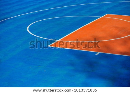 Abstract, blue background of newly made outdoor basketball court in park. Visible asphalt texture, freshly painted lines