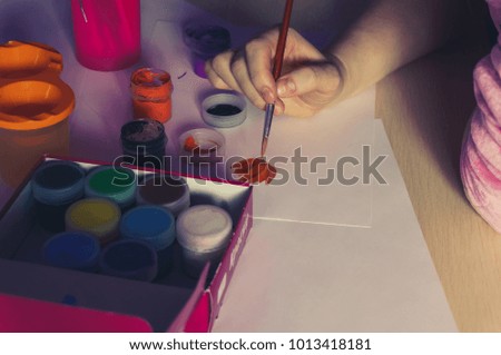 Artist's hand with brush painting a picture