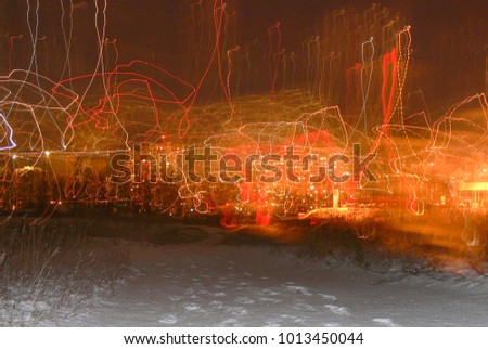 an abstract depiction of a winter city at night with footprints in the snow, lights and multicolored luminous lines