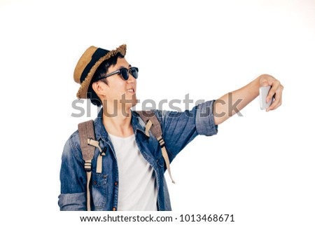 Young Asian tourist smiling and taking a selfie isolated over white background