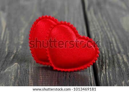 Two red heart on wooden table