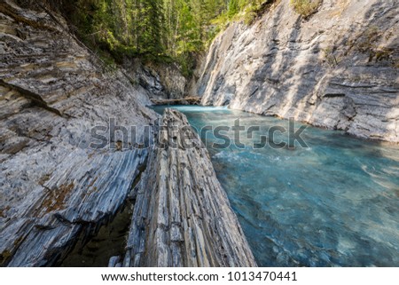 Beautiful clear turquoise mountain river below the natural bridge new Radium Hot Springs British Columbia on the Nipika Trails. Royalty-Free Stock Photo #1013470441