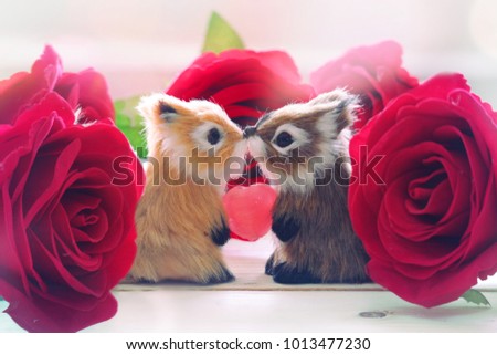 Two squirrels are giving candy surrounded by red roses in Valentines day.
