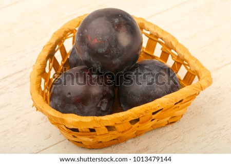 Ripe fresh plums over the wooden background