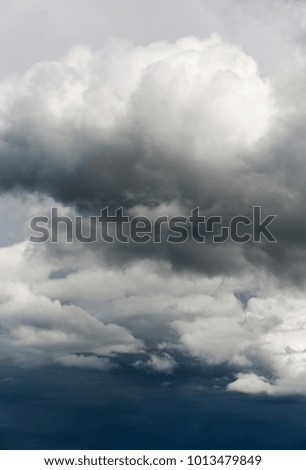 Gray and white storm clouds on a dark blue sky