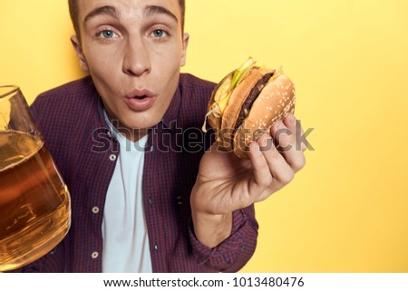  man with a hamburger, a mug of beer on a yellow background                              