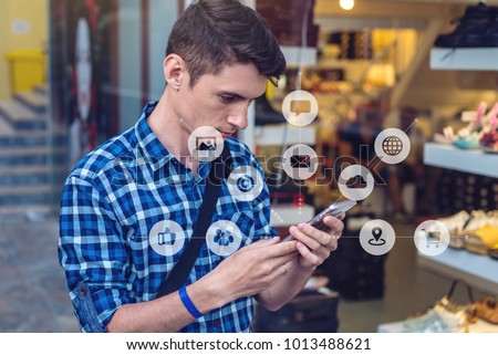 A man uses a smartphone to access social digital media in the Internet: shopping, entertainment, search and file storage. The concept of a global network expansion